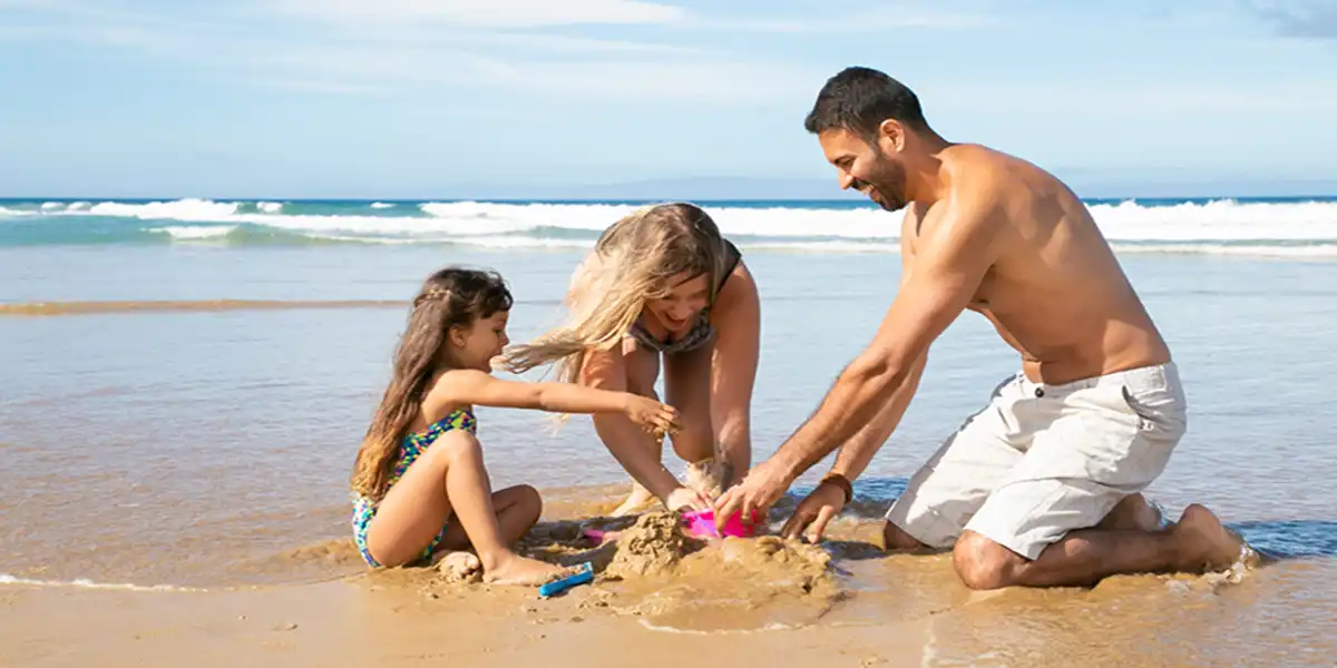 Father's Day Father Mother Young Girl at Beach Vacation Atlantic Ocean Background Young Family building Sand Castle